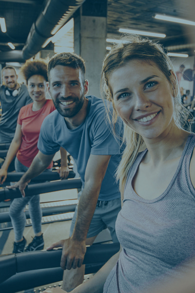 Several adults on treadmill machines