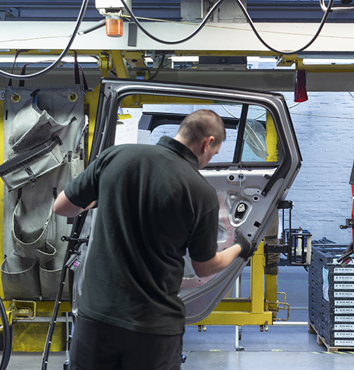 Industrial worker assembling car parts.