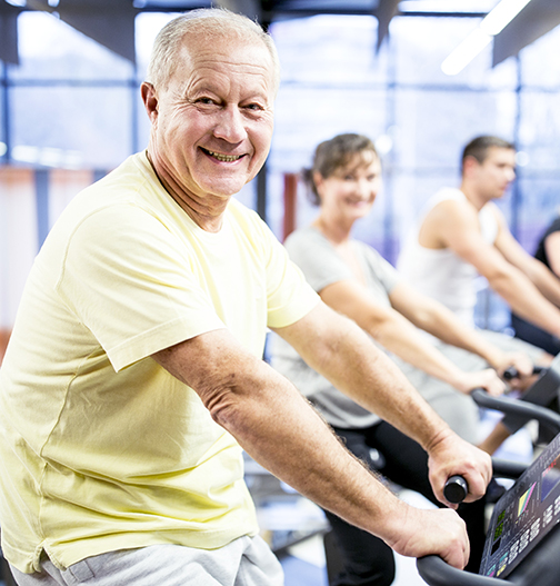 Happy man working out on a stationary bike.