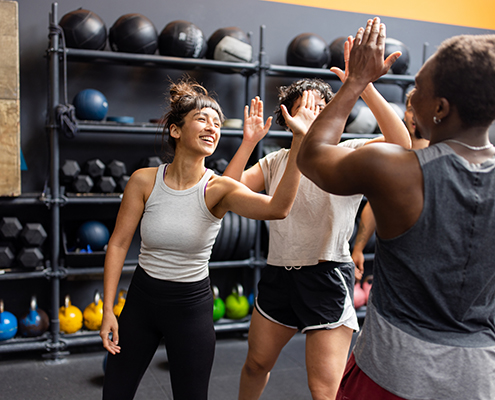 People in a gym high-fiving each other