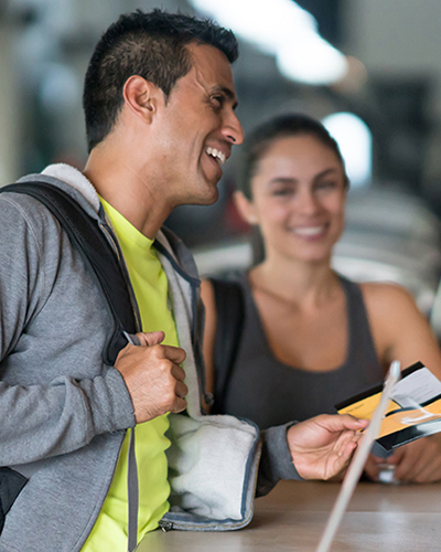 Fitness members checking in at a desk with attendent