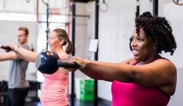 woman and group fitness with kettle bells